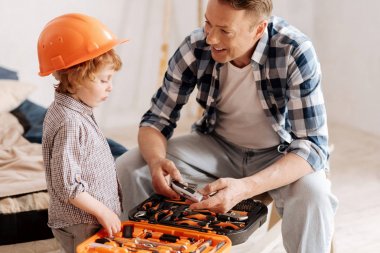 Özenli çocuk yarı pozisyonda dururken turuncu miğfer