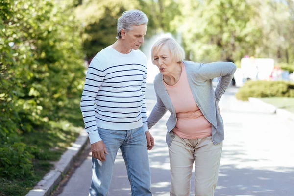 Puzzled pensioner caring about senior wife outdoors — Stock Photo, Image