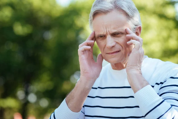 Pensionista confundido sintiendo terrible dolor de cabeza al aire libre — Foto de Stock