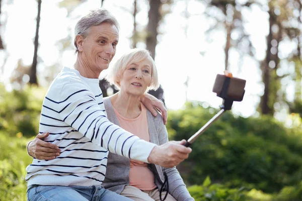 Позитивная пожилая пара делает селфи на открытом воздухе — стоковое фото