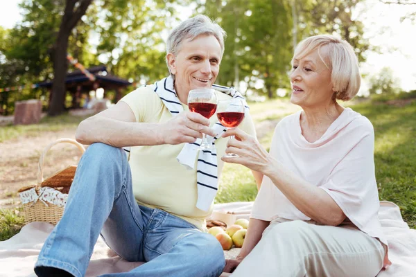 Smiling aged couple enjoying conversation in the park — Stock Photo, Image