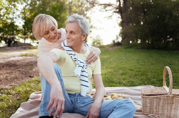 Оптимистичная пожилая пара делится позитивом на пикнике — стоковое фото