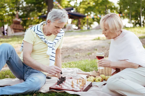 Залучена пара на пенсії грає в шахи в парку — стокове фото
