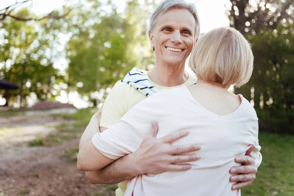 Χαρούμενος συνταξιούχος αγκαλιάζει τη γυναίκα του στο πάρκο — Φωτογραφία Αρχείου