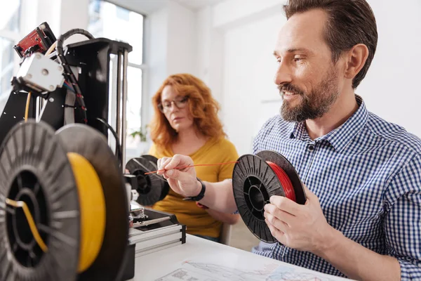 Gioioso uomo positivo che collega il filamento alla stampante 3d — Foto Stock