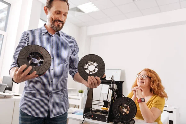 Gelukkig positieve man kijken naar de filamenten spoelen — Stockfoto