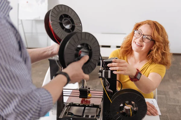Mujer positiva encantada tomando bobinas de filamento —  Fotos de Stock