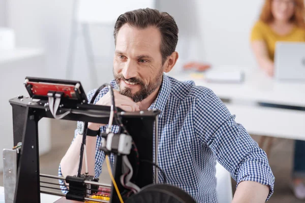 Designer feliz alegre sentado na frente de uma impressora 3d — Fotografia de Stock