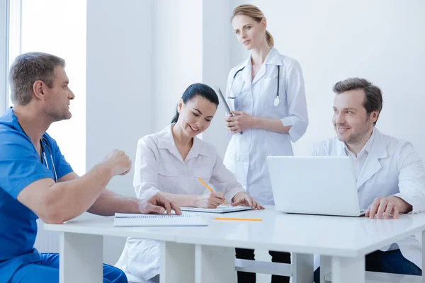 Animados colegas médicos disfrutando de la sesión informativa matutina en el hospital — Foto de Stock