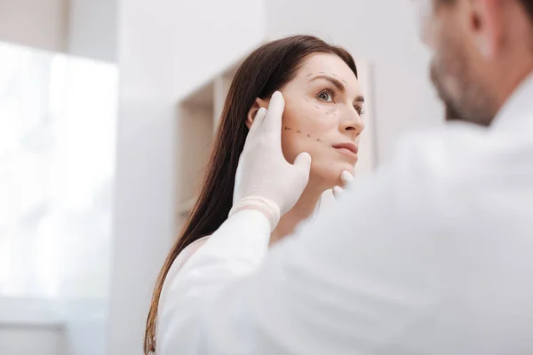 Diligent bright plastic surgeon in the middle of the process — Stock Photo, Image