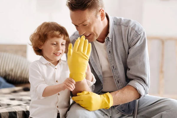 Uśmiechnięty chłopiec ogląda dłoń z jego tata — Zdjęcie stockowe