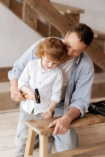 Delighted boy driving nail into wood — Stock Photo, Image