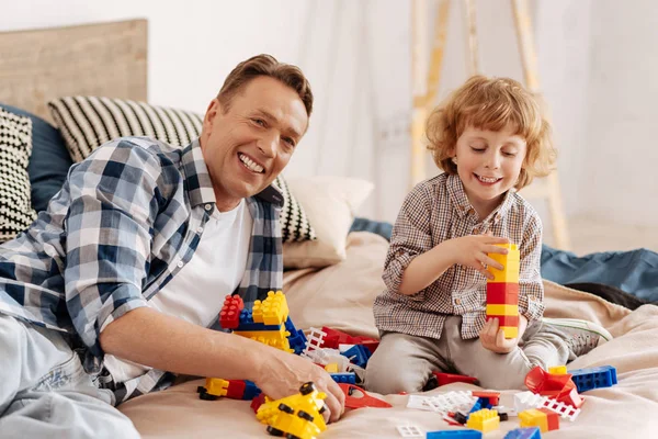 Homem positivo brincando com seu filho encantado — Fotografia de Stock