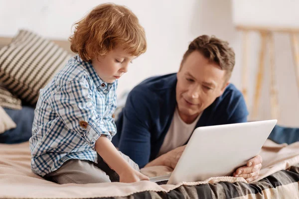 Ernstige jongen naar beneden kijken op computer — Stockfoto