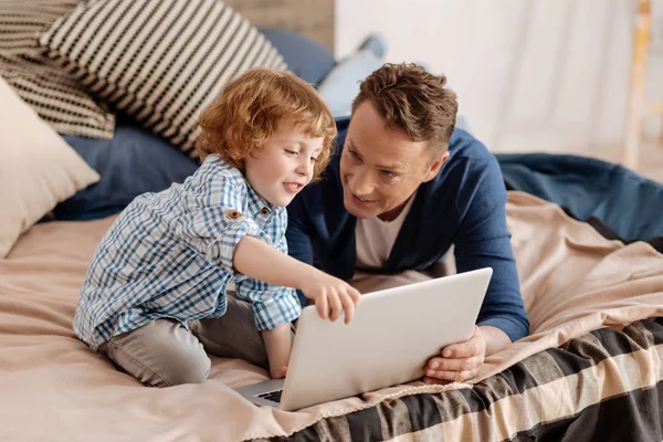 Jongetje aanraken van de laptop van zijn vader — Stockfoto