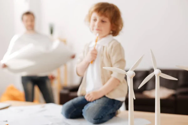 Focused photo on models of windmills that standing on the foreground