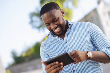 Meraklı heyecanlı adam izliyor bazı eğlenceli şeyler üstünde onun becerikli alet