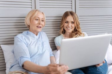 Mother and daughter immersed into watching video clipart