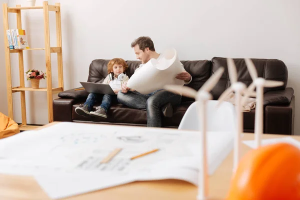 Encantados padre e hijo sentados en un sofá de cuero — Foto de Stock