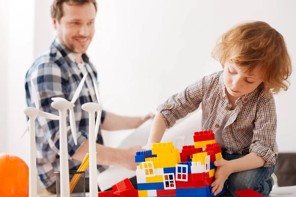 Menino apaixonado fazendo casa de brinquedo no trabalho de seu pai — Fotografia de Stock