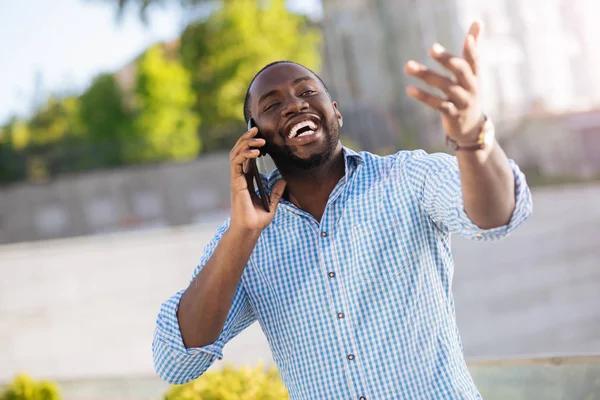 Energisk upphetsad man chattar på telefonen upphetsat — Stockfoto