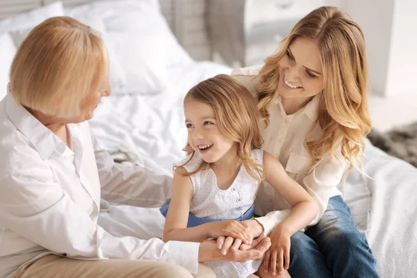 Lovely grandchild listening to her grandmother telling jokes — Stock Photo, Image