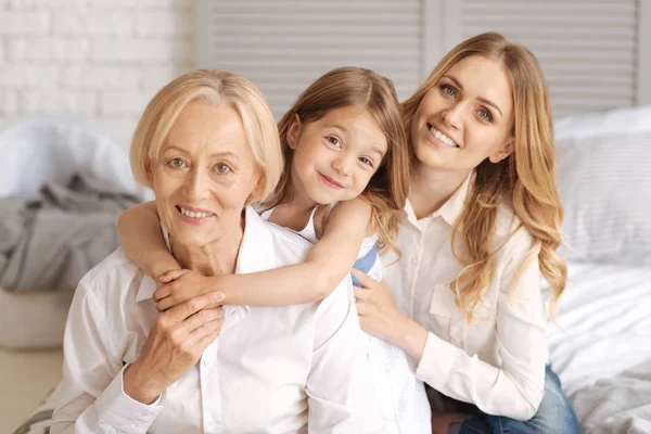 Three generations of females sitting behind each other — Stock Photo, Image