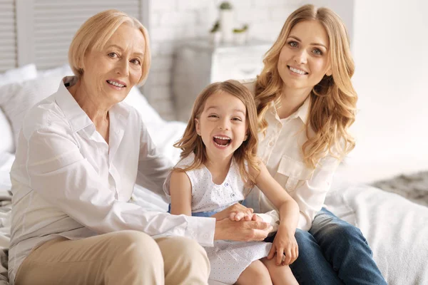 Chica riendo en el abrazo de su madre y su abuela — Foto de Stock