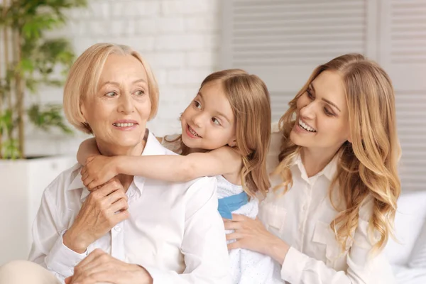 Cheerful amused mother and child looking at the grandmother — Stock Photo, Image
