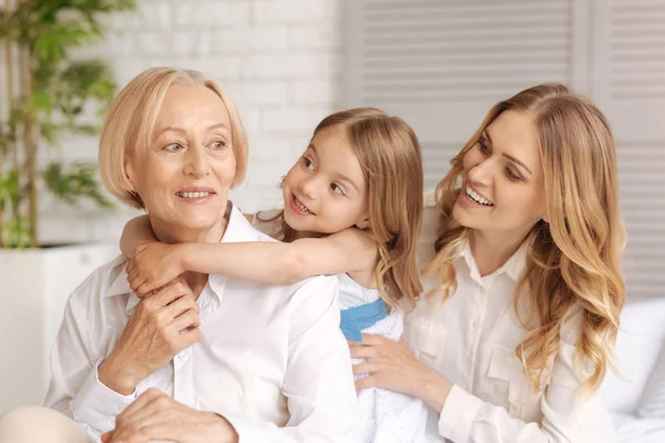 Vrolijke geamuseerd moeder en kind te kijken naar de grootmoeder — Stockfoto