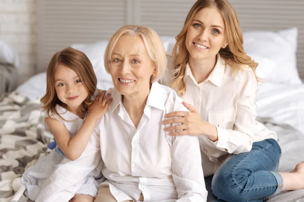 Child and her mother having hands on grandmothers shoulders — Stock Photo, Image