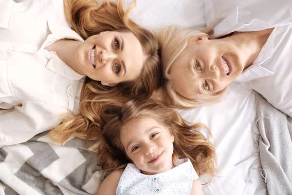 Charming three females of different age lying head to head — Stock Photo, Image