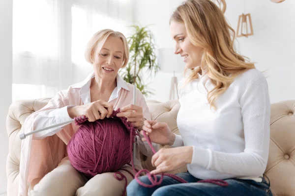 Mujer joven ayudando a su madre con el tejido —  Fotos de Stock