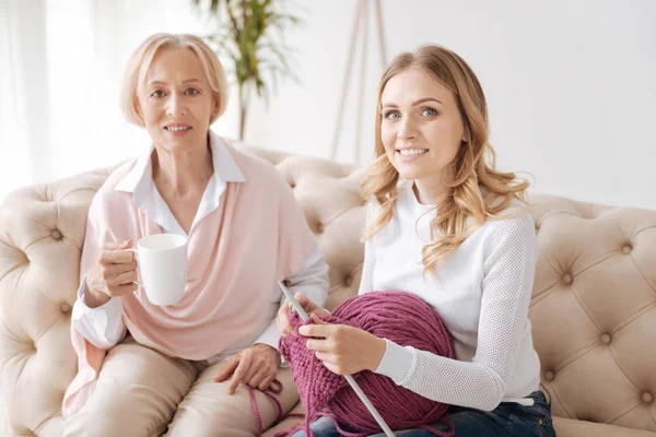 Adulti figlia e sua madre seduti sul divano insieme — Foto Stock