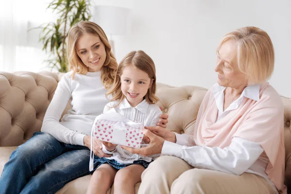 Grandmother presenting a gift to her little granddaughter — Stock Photo, Image