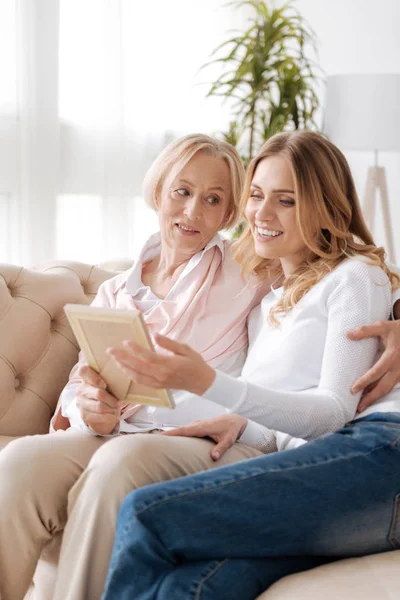Senior mother and her daughter looking at a photo — Stock Photo, Image