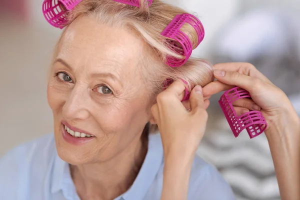 Femme âgée obtenir de l'aide avec les rouleaux de cheveux — Photo