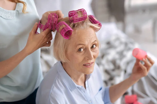 Mãos femininas ajudando a corrigir rolos de cabelo — Fotografia de Stock