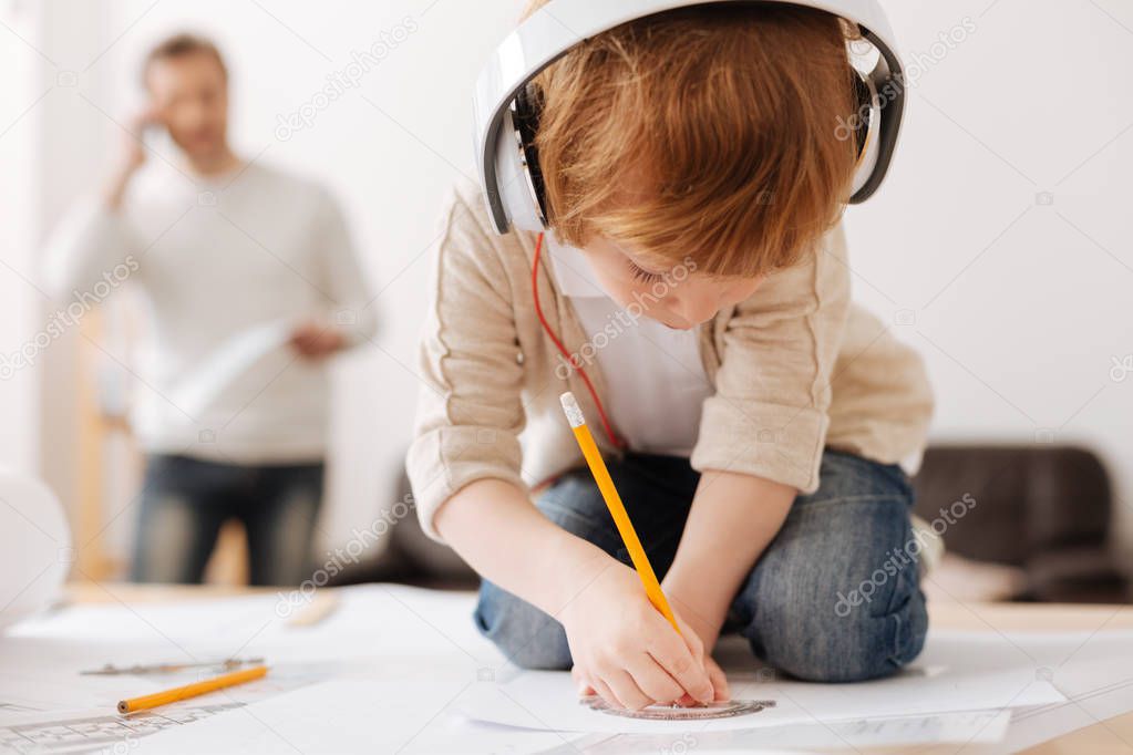 Attentive boy bowing head while drawing picture