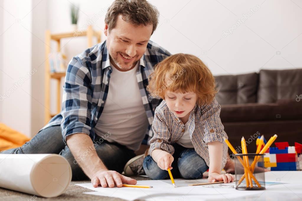 Positive delighted male person spending time with his son