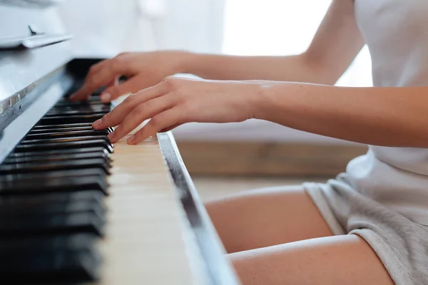 Jonge vrouw speelt thuis piano — Stockfoto