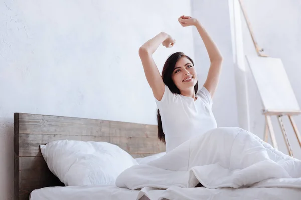 Jovem senhora feliz esticando os braços na cama — Fotografia de Stock