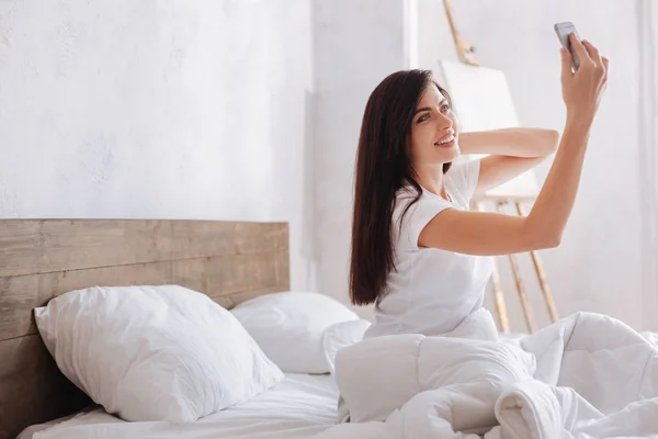 Morena tomando autorretrato en la cama — Foto de Stock