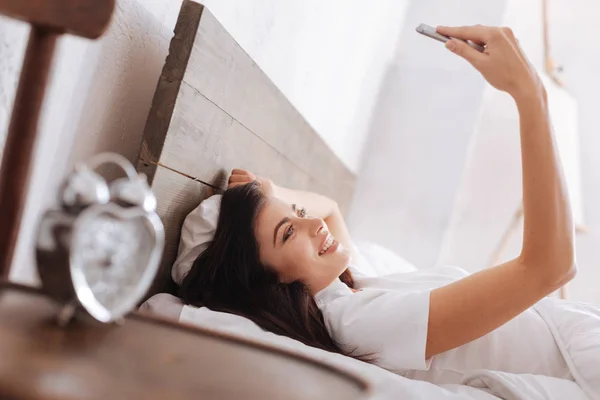 Jovem senhora sorrindo amplamente enquanto toma selfie — Fotografia de Stock