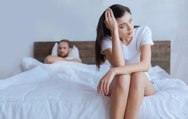 Upset woman with angry husband behind — Stock Photo, Image