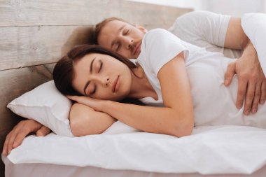 Evde rahat yatakta uyuyan Çift