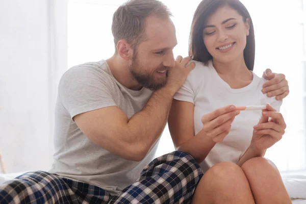 Портрет взволнованной супружеской пары, смотрящей тест на беременность — стоковое фото