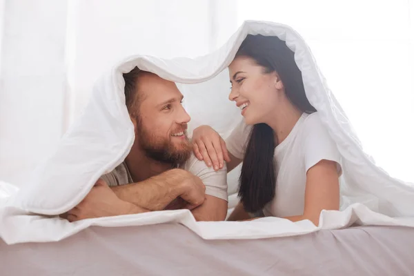 Pareja cubierta de manta mirando a los ojos — Foto de Stock