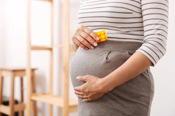 Pregnant woman holding pills — ストック写真