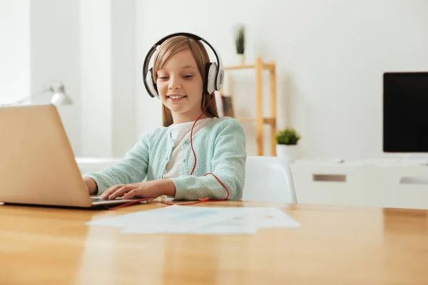 Chica animada inspirada escuchando música mientras estudia —  Fotos de Stock